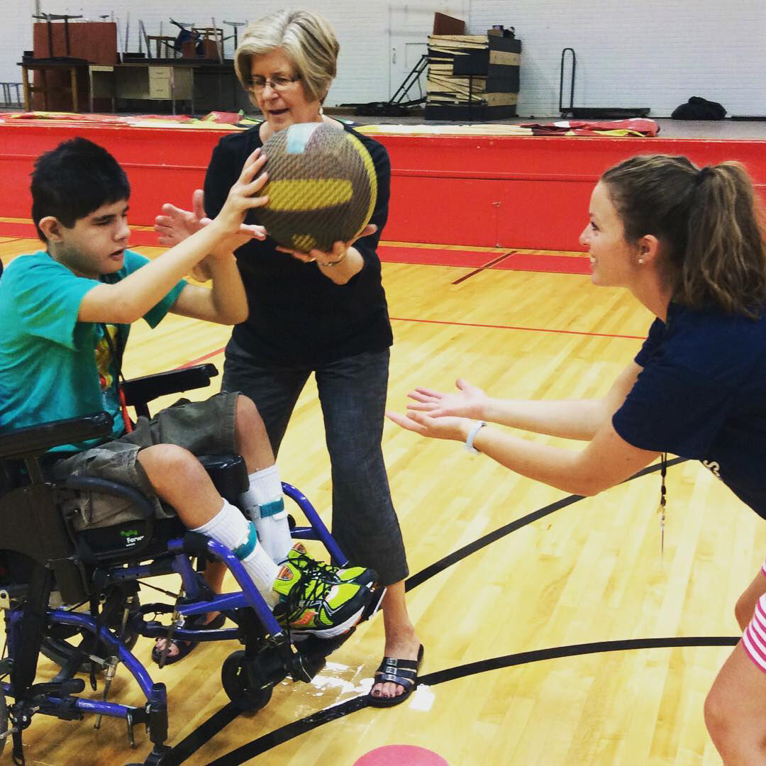 Danielle Musser works with student in gym